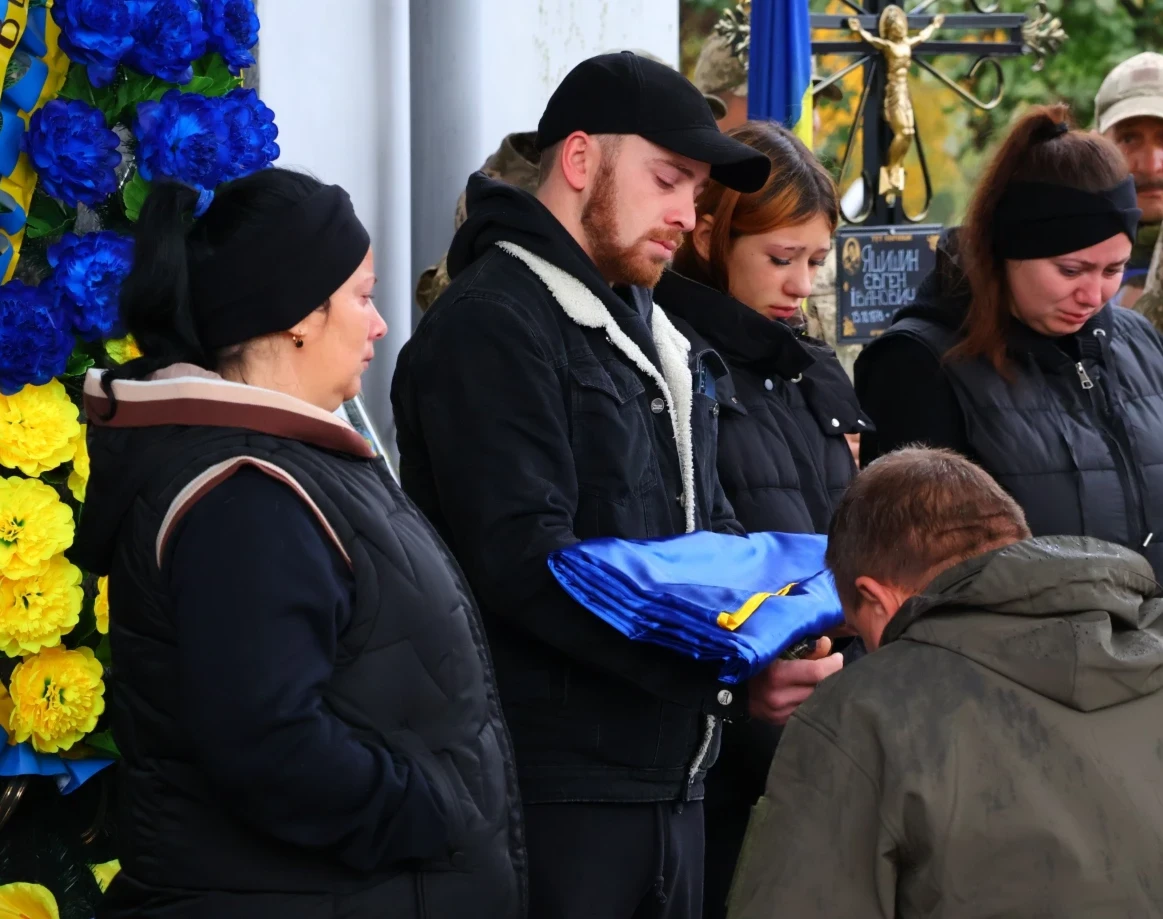 Андрій Чорний передає Державний прапор України сину Євгена Яцишина.
