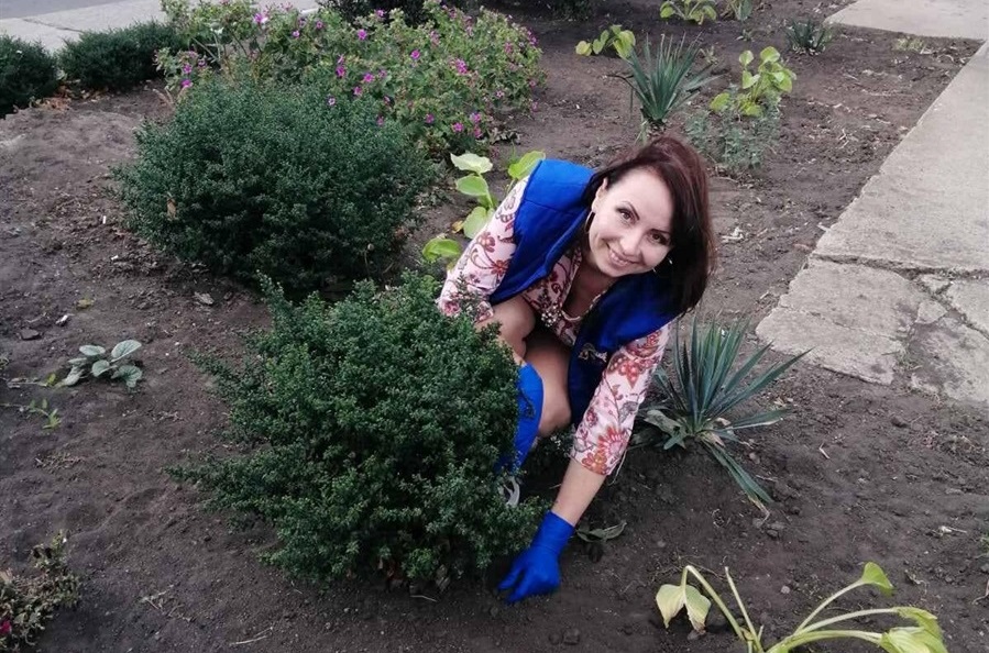 Ольга хоче зробити місто красивим тому влсноруч висаджує квіти на клумбах