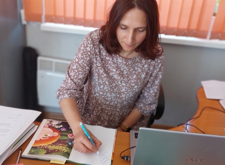 Світлана Аман підписує книгу для музею