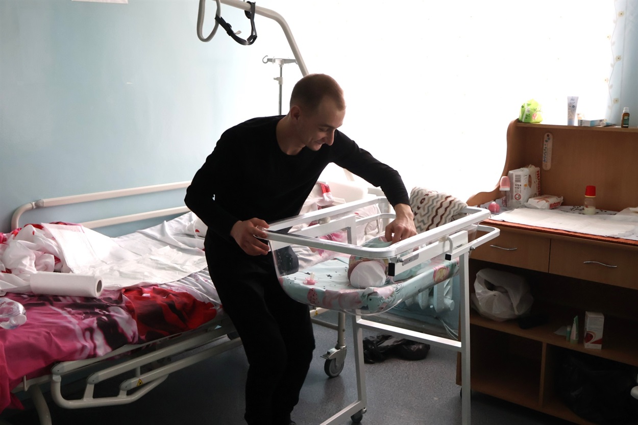 Щасливий татусь турбується про новонароджену донечку.