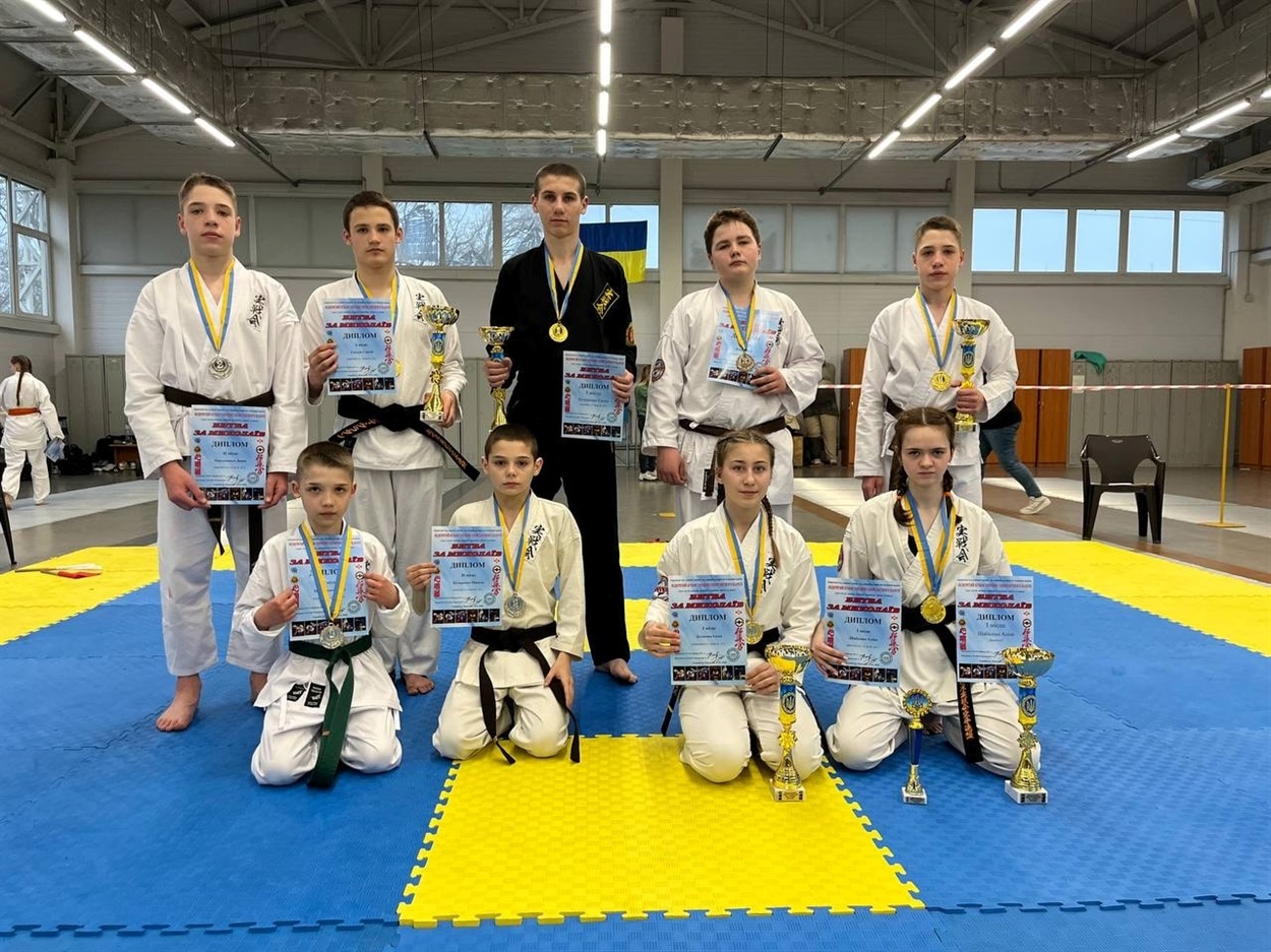 Команда Джісенкай карате WJKF з Південноукраїнська на нагородженні після перемоги на турнірі «Битва за Миколаїв», тримаючи грамоти та медалі.