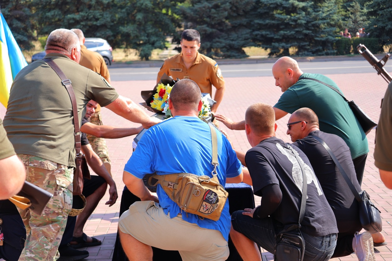 Побратими поклали до труни квіти і стали на коліно в знак шани.