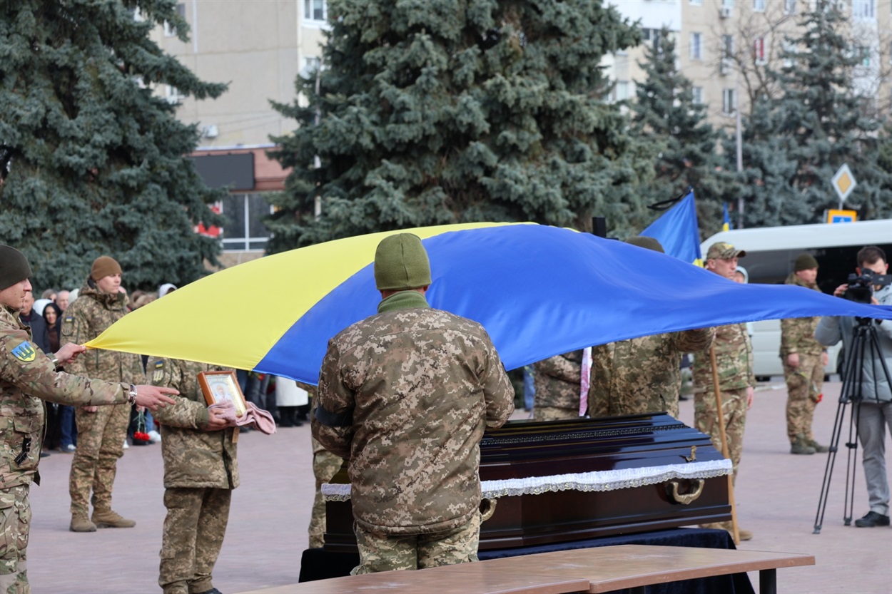 Полотнищем Державного прапора обгорнули домовину загиблого захисника