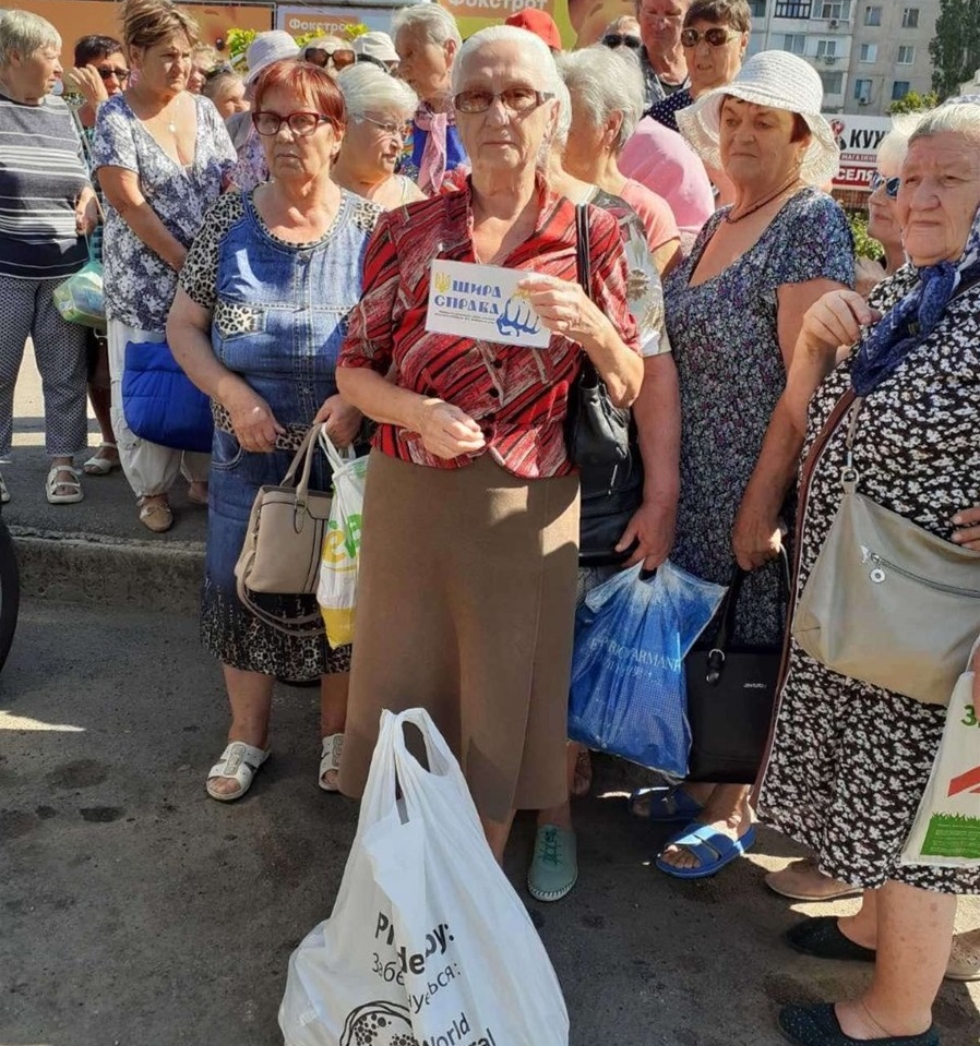 Продуктові набори Сергій роздає переселенцям просто неба.